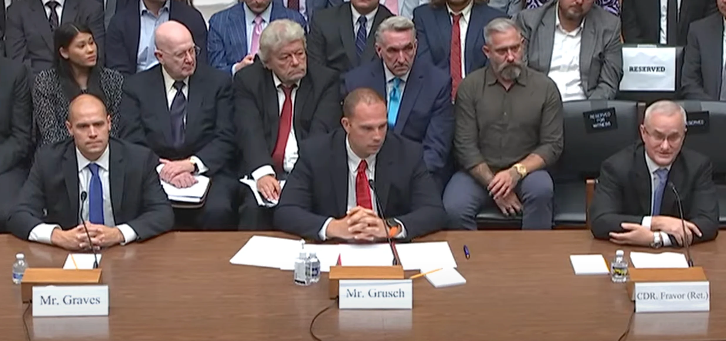 Ryan Graves, David Grusch, and David Fravor seated at the witness table during the July 26, 2023, House Oversight Committee hearing, with Fravor on the right.